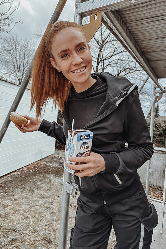 Anlagenmechanikerin Sandra Hunke mit Handwerkerbrötchen und Kakao in der Hand